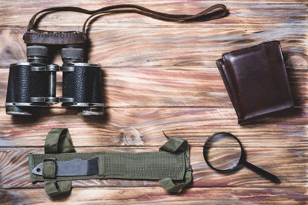 Wooden background with binoculars and others travel objects