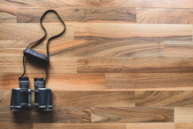 Wooden background with binoculars