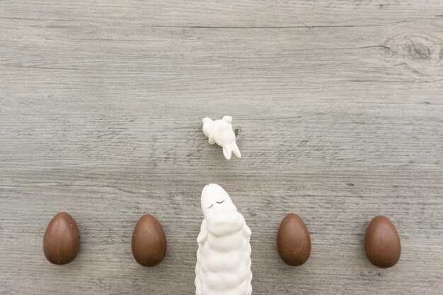 Деревянный фон с шоколадные яйца и овец в день Святой Пасхи