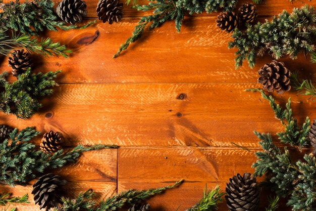 Wooden background with christmas tree cones frame