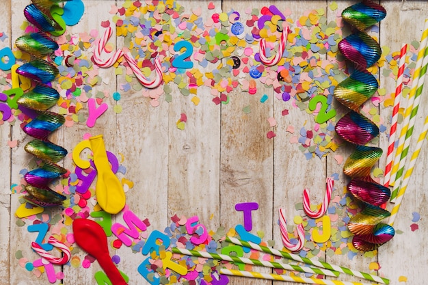 Wooden background with confetti and streamers around
