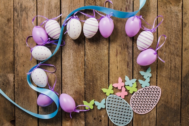 Free photo wooden background with decorative easter eggs and butterflies