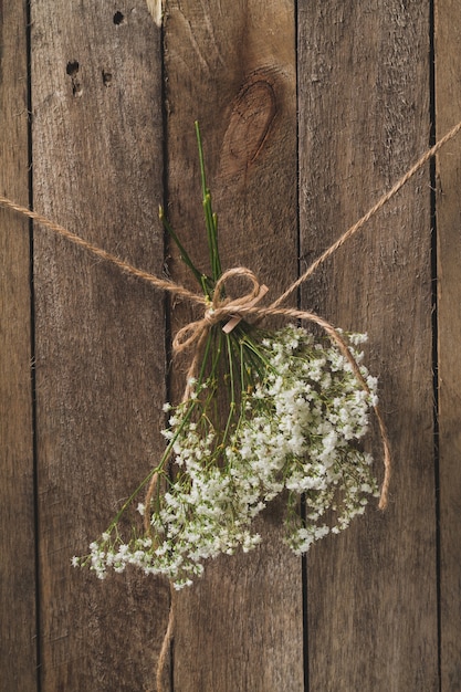 Wooden background with floral decoration tied with a rope