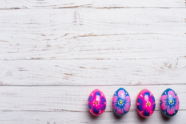 Wooden background with four easter eggs