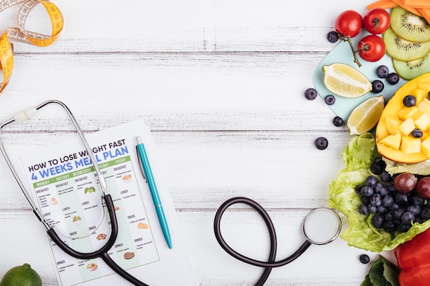 Wooden background with fruit and stethoscope