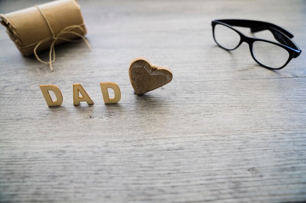 Wooden background with glasses and gift for father's day