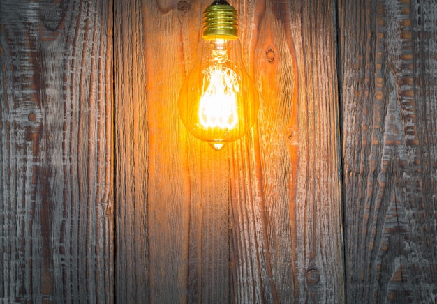 Free photo wooden background with illuminated light bulb