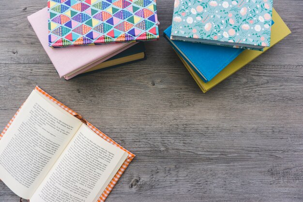 Wooden background with open book and stacked books