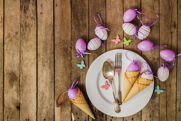 Wooden background with plate and decorative easter eggs