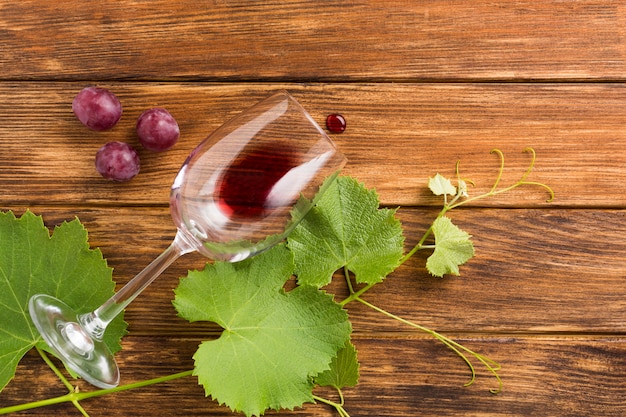 Wooden background with red grapes and vines