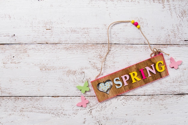 Wooden background with spring sign and decorative butterflies