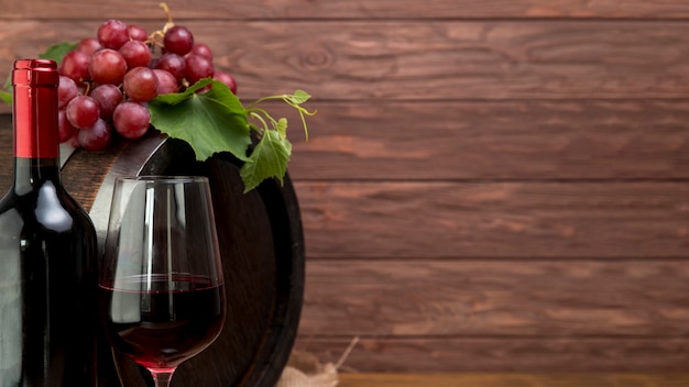 Деревянная бочка с бутылкой и бокалом вина