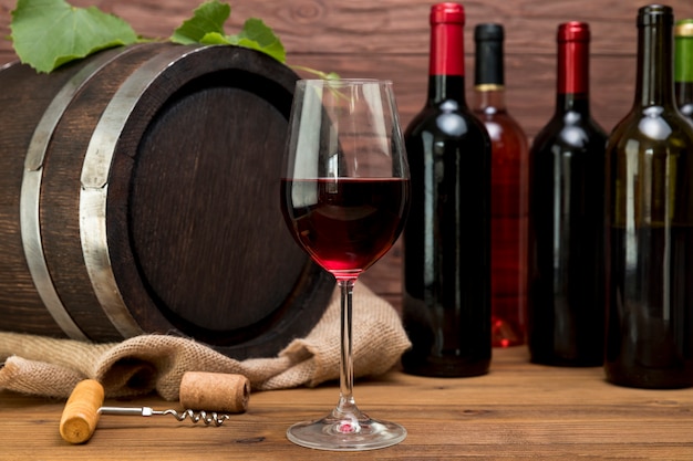 Wooden barrel with bottles and glasses of wine