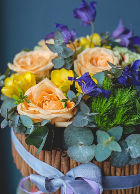 A wooden basket of sweet colour roses for a gift.