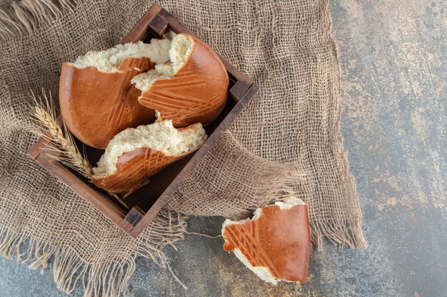 A wooden basket of sweet delicious pastry on a sackcloth