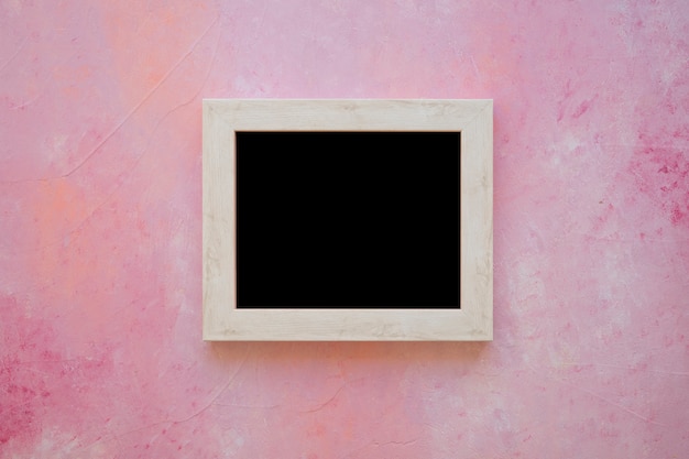 ピンクの塗られた背景に木製の黒板