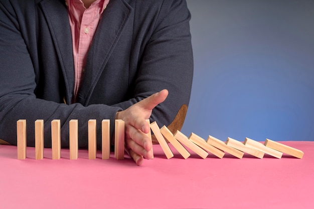 Wooden blocks falling representing economy