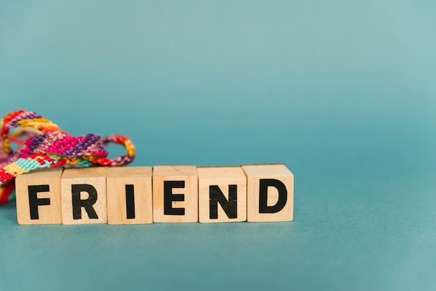 Wooden blocks with text friends and multicolored bracelets