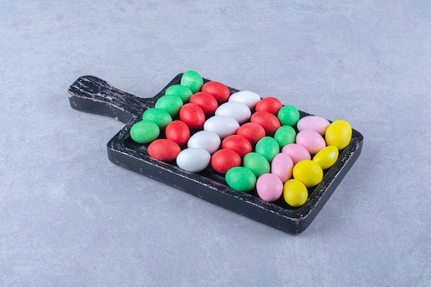 Деревянная доска красочных сладких конфет мармелада. Фото высокого качества