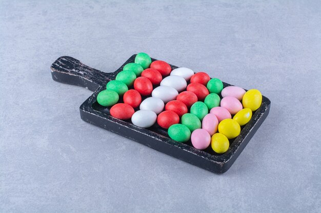 A wooden board of colorful sweet jelly bean candies . High quality photo