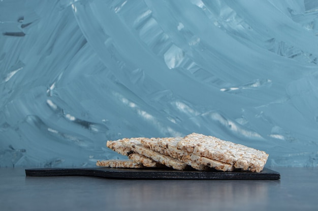 A wooden board of crispy square rice waffles.