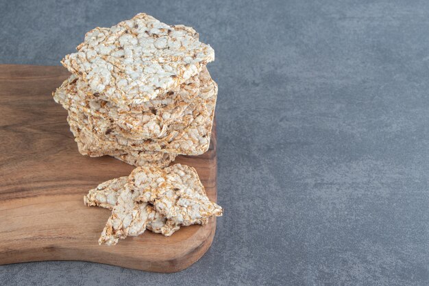 A wooden board of crispy square rice waffles.