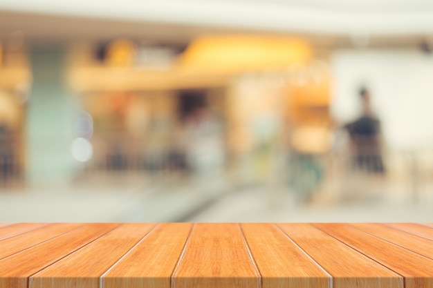 Wooden board empty table blurred background. Perspective brown wood over blur in department store - can be used for display or montage your products.Mock up for display of product.