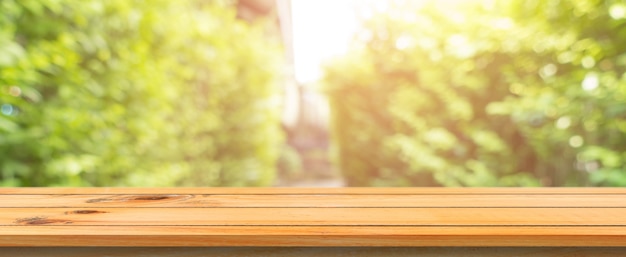 Wooden board empty table blurred background. Perspective brown wood table over blur trees forest background - can be used mock up for display or montage your products. spring season. panoramic banner.