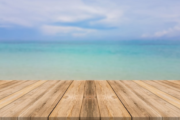 Wooden board empty table top blur sea & sky background. Perspective brown wood table beach background - can be used mock up for montage products display or design key visual layout. summer concepts.
