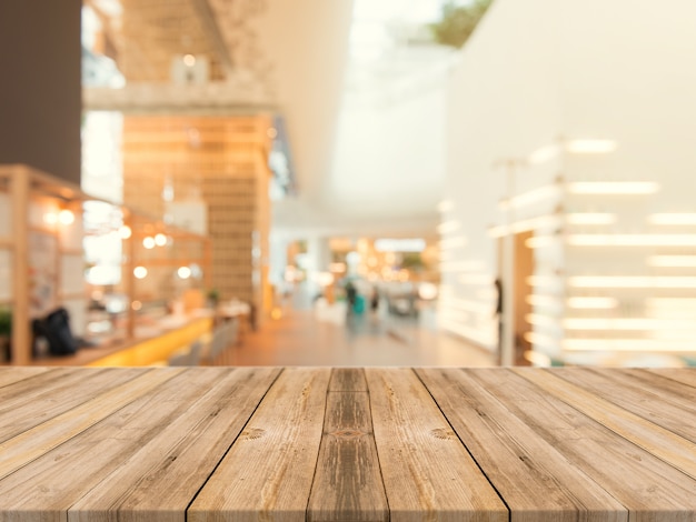 Wooden board empty table top on of blurred background. Perspective brown wood table over blur in coffee shop background - can be used mock up for montage products display or design key visual layout.