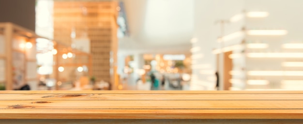 Wooden board empty table top blurred background. perspective brown wood table over blur in coffee shop background. panoramic banner - can be used mock up for montage products display or design.