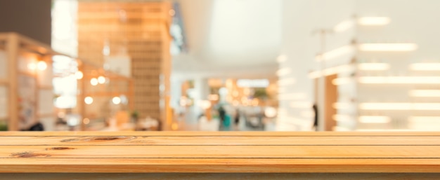 Wooden board empty table top blurred background. Perspective brown wood table over blur in coffee shop background. Panoramic banner - can be used mock up for montage products display or design.