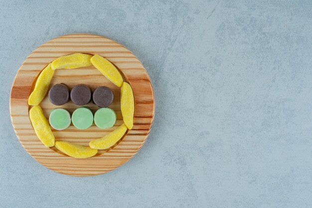 バナナの形をした咀嚼キャンディーとゼリー菓子がいっぱいの木の板