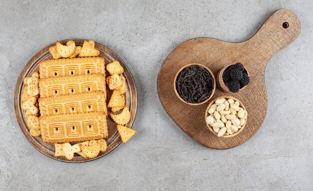 A wooden board full of biscuits on marble surface.