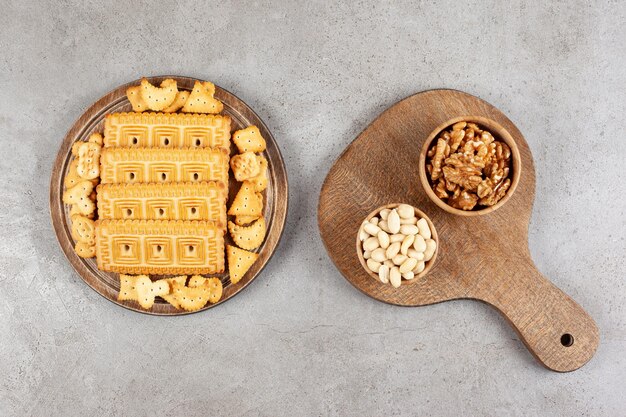 A wooden board full of biscuits on marble surface.