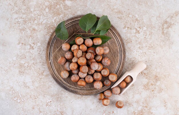 A wooden board full of healthy macadamia nuts .