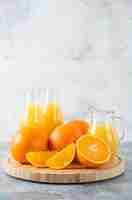 Free photo a wooden board full of juicy slices of orange fruit on stone table .