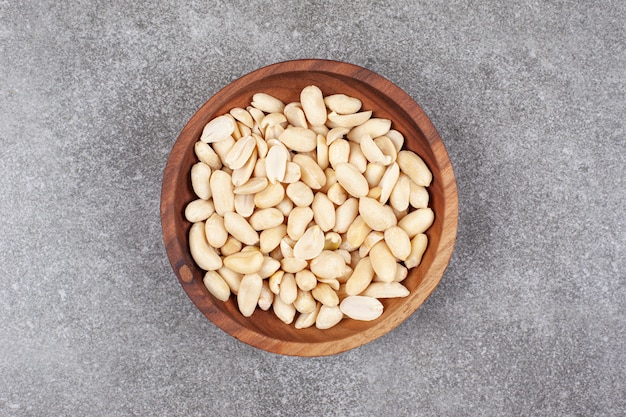 A wooden board full of peeled almonds 