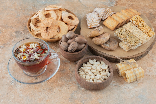 Una tavola di legno piena di biscotti dolci e una tazza di tisana