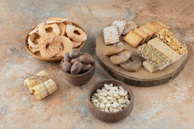 A wooden board full of sweet cookies on marble background