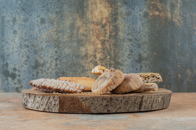 Free photo a wooden board full of sweet cookies and peanut brittles