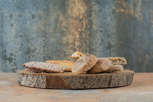 A wooden board full of sweet cookies and peanut brittles
