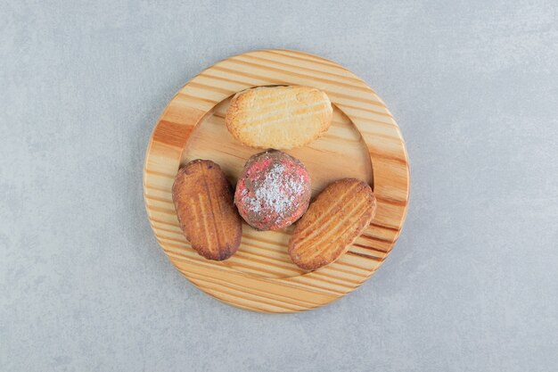 A wooden board full of sweet cookies .  