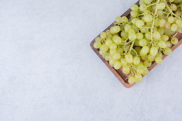 A wooden board full of sweet grapes on white background. High quality photo