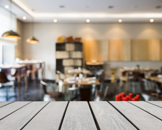 Tavola di legno che guarda fuori ai tavoli nel ristorante