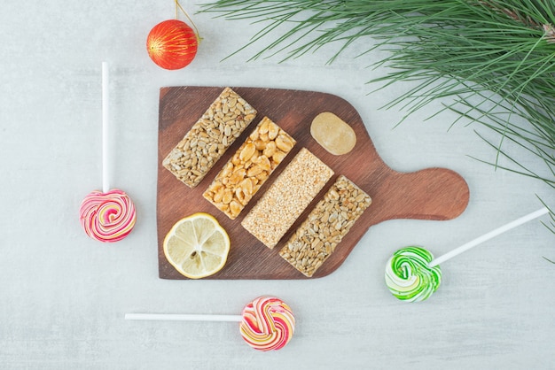 A wooden board of peanut brittle and slice of lemon . High quality photo