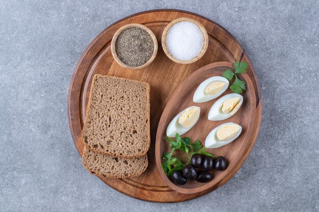 A wooden board with boiled eggs and slice of bread. High quality photo