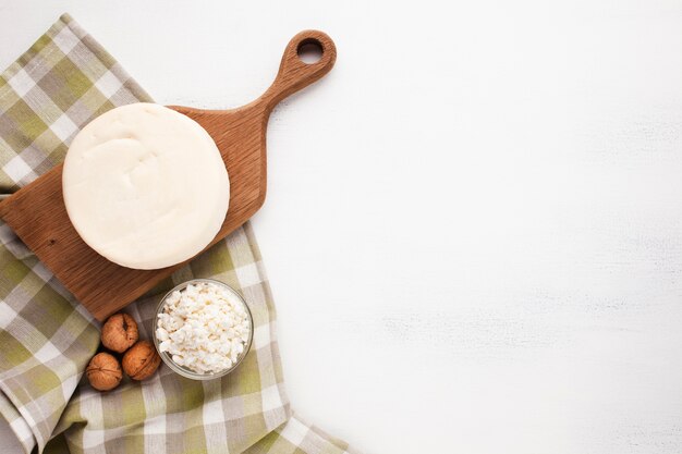 Wooden board with cheese copy space