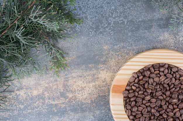 A wooden board with coffee beans on marble background. High quality photo