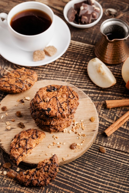 Wooden board with cookies and cup of tea